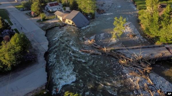 A house sits in Rock Creek after floodwaters washed away a road and a bridge in Red Lodge, Mont., June 15, 2022.