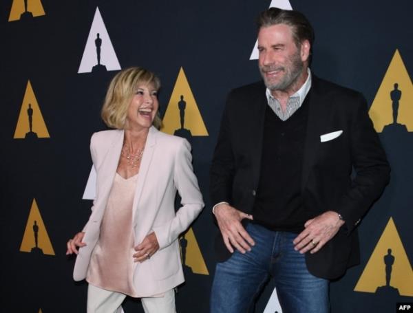 FILE - Actors Olivia Newton-John and John Travolta dance on the red carpet as they arrive for the 40th anniversary celebration of the movie 