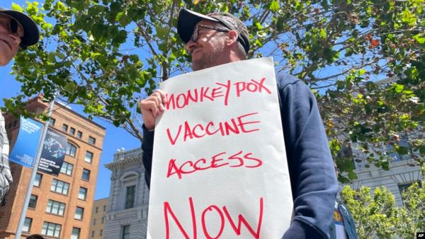 FILE - A man holds a sign urging increased access to the mo<em></em>nkeypox vaccine during a protest in San Francisco, July 18, 2022. 
