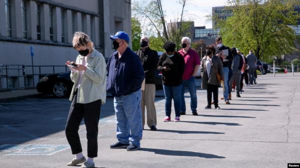 FILE - People line up outside a newly reopened career center for in-person appointments in Louisville, April 15, 2021.
