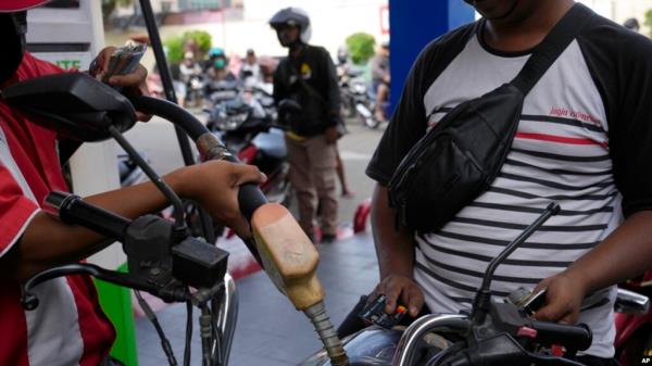 An attendant fills up the tank of a motorbike at a gasoline station in Jakarta, Indonesia, Sept. 3, 2022.