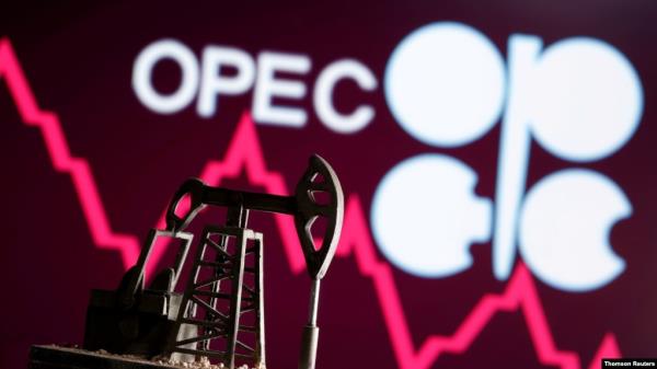 FILE - A 3D printed oil pump jack is seen in front of displayed stock graph and OPEC logo in this illustration picture.